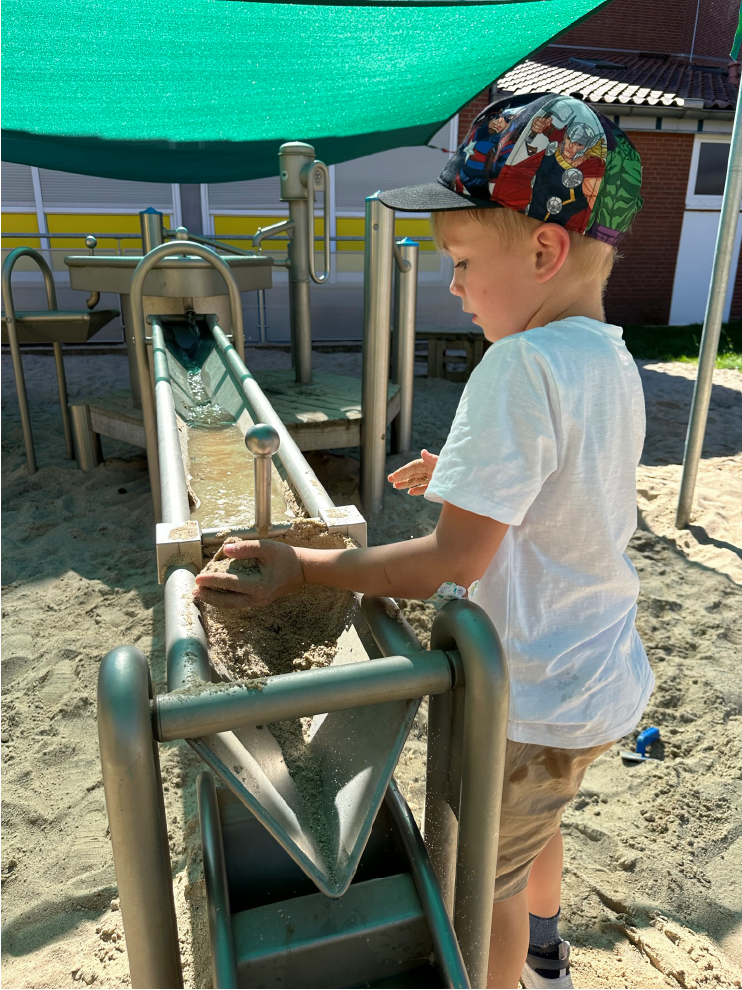 Broschuere-Kindergarten_kind_hauotbild Small boy playing on a play device that has a water channel