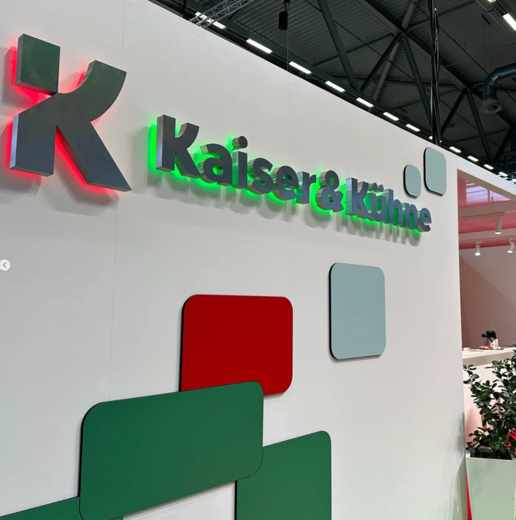 Logo von Kaiser und Kühne mit Belichtung von hinten in Rot und Grün auf der Messe